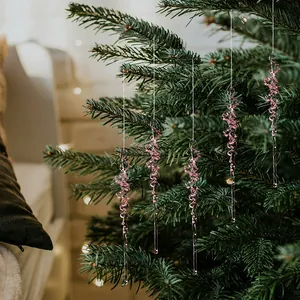 Vue détaillée de glaçons en acrylique rose suspendus à une branche de sapin