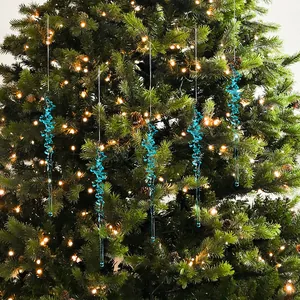 Élégant ensemble de cinq glaçons en acrylique bleu suspendus à un sapin de Noël.