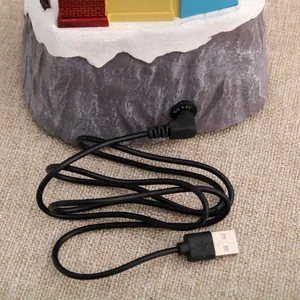 Close-up view of the DC 4.5V power port and USB charging cable for the musical house.