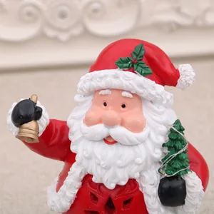 Nahaufnahme der Weihnachtsmann-Harzfigur mit goldener Glocke und kleinem Weihnachtsbaum