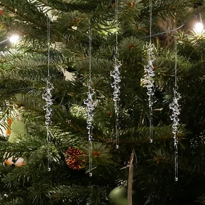 Vue détaillée de cinq ornements de glaçons en acrylique clair sur un sapin de Noël
