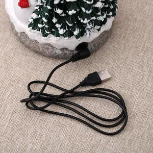 Detailed close-up showing the USB power cable connected to resin Christmas musical house