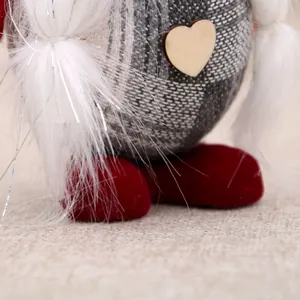 Close-up of Christmas gnome detail with plaid fabric, wooden heart, and red plush feet.