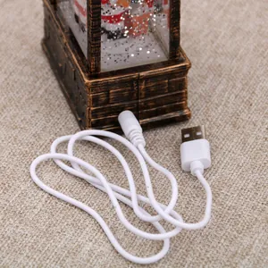 Detail of the white USB power cable connection for Christmas musical oil lamp