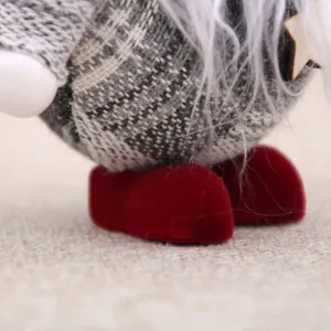 Close-up detail of plush Christmas gnome with red velvet boots and grey plaid fabric.