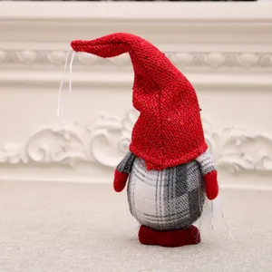 Back view of a faceless Christmas gnome with a red knitted hat and plaid body