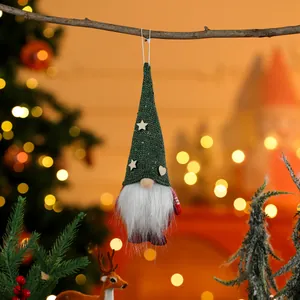Detailed view of a green knit Christmas gnome ornament hanging from a tree branch.