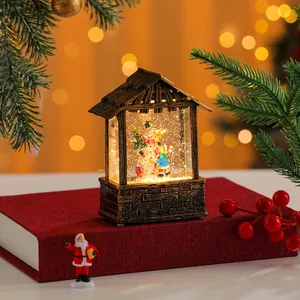 Detailed view of a festive lighted house lantern with snow globe effect and snowman inside