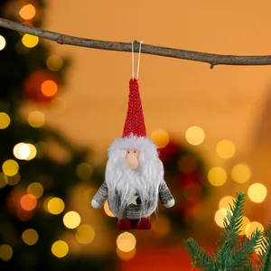 Close-up of a plush Christmas gnome ornament hanging from a tree branch
