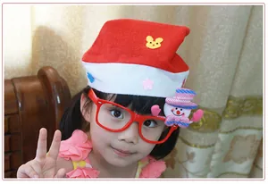 Close-up of a child wearing a red Christmas hat and festive snowman decorative glasses