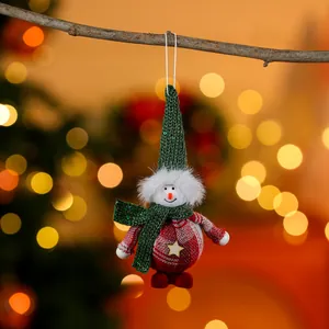 Detail of a handmade fabric Christmas snowman ornament hanging on a branch