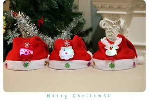 Detail von drei LED-leuchtenden Weihnachtsmützen mit süßen Cartoon-Figuren