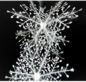 Detalle de una guirnalda de copos de nieve de Navidad en 3D blancos con hilo brillante.