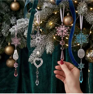 Detailansicht von Acryl-Schneeflocken- und Eiszapfen-Anhängern am Weihnachtsbaum.