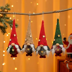 Detailansicht von vier farbenfrohen handgefertigten Weihnachtswichteln an einem Ast