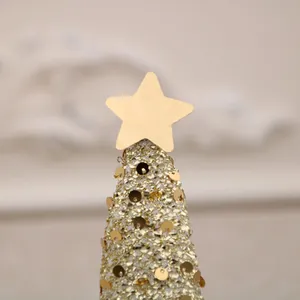 Detailed close-up view of a shimmering gold sequin Christmas tree topper with star