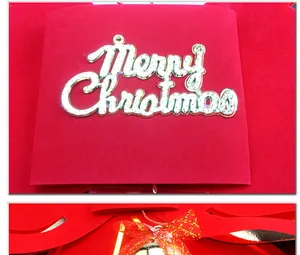 Detailansicht einer festlichen roten Weihnachtsschleife mit Goldglocke und Merry Christmas Schild