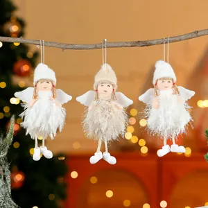 Detail von drei süßen Plüsch-Engelsfiguren, die an einem Zweig zu Weihnachten hängen