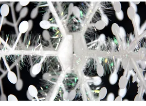 Detalle macro de un copo de nieve de Navidad blanco con espumillón irisado brillante