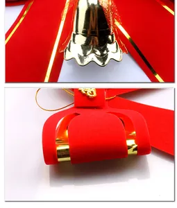Detail einer roten Samt-Weihnachtsschleife mit einer glänzenden goldenen Glocke