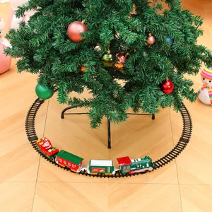Detailansicht eines elektrischen Weihnachtszug-Sets, das einen Baum auf Holzboden umkreist