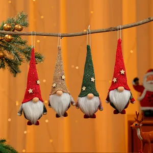 Detailansicht von vier bunten Weihnachtsgnom-Ornamenten, die an einem Ast hängen