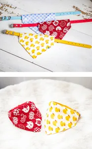 Close-up of cute pet bandana collars with duck and cat patterns on white fur