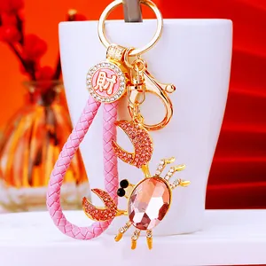 Close-up of a pink crab keychain with sparkling rhinestones and elegant golden hardware