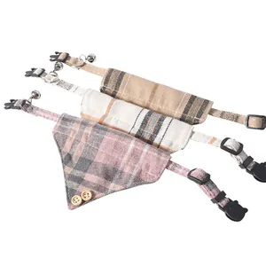 Detailed view of three plaid cat collars and bandanas with bells on white background.