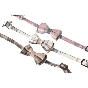 Detailed macro view of three British style plaid cat collars with cute bowties and bells