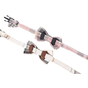 Close-up of British plaid cat collars featuring bowties, plastic buckles, and bells.