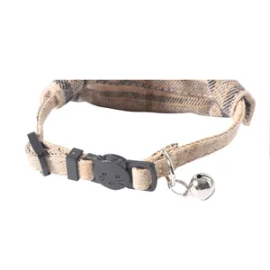 Detailed view of British plaid cat collar with cat-shaped buckle and silver bell