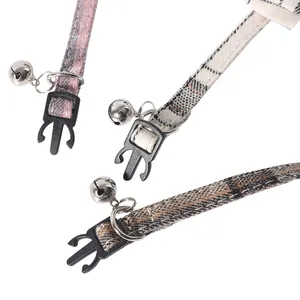 Detailed macro shot of plaid fabric pet cat collars featuring bells and plastic buckles