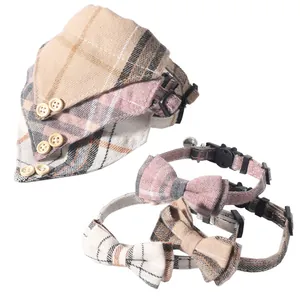 Detail of British plaid cat collar and bandana set with bow ties and small bells.