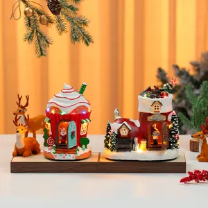 Detailed view of two glowing Christmas resin musical box ornaments featuring cake and boot designs.