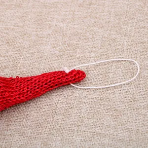 Detailansicht eines rot gestrickten Weihnachtsschmucks mit Aufhängeschlaufe und Textur