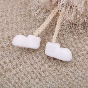 Makrodetail weißer Filzstiefel und beiger Seilbeine an einem Plüsch-Engelsornament