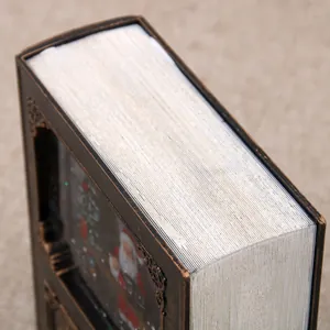 Vista dettagliata di un carillon natalizio a forma di libro con trame di pagine bianche.