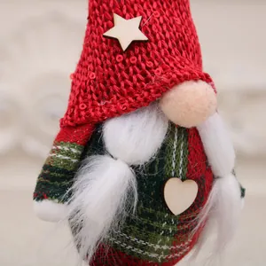 Nahaufnahme einer dekorativen Weihnachtsgnom-Puppe mit roter Strickmütze und weißen Zöpfen.