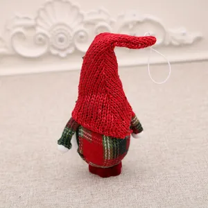 Nahaufnahme einer kleinen Weihnachtsgnom-Verzierung mit roter Strickmütze und Karomuster