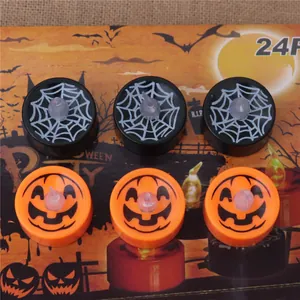 Close-up of Halloween LED tea lights with pumpkin and spider web designs