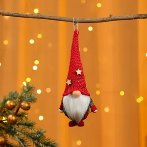 Nahaufnahme eines festlichen roten gestrickten Weihnachtsgnom-Ornaments an einem Ast