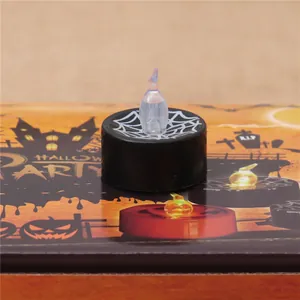 Detailed close-up of a black LED tea light candle with a white spider web design.