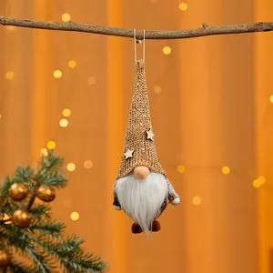 Detailansicht eines glitzernden Weihnachtswichtels, der an einem Ast hängt