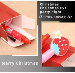 Détail d'un ensemble de papeterie de Noël avec un stylo rouge et un capuchon fraise festif
