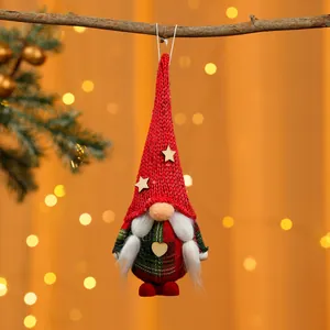 Nahaufnahme eines handgefertigten roten gestrickten Weihnachtswichtel-Anhängers am Ast