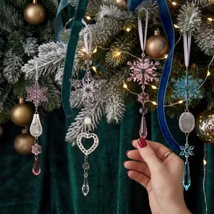 Elegante weihnachtliche Acryl-Schneeflocken- und Eiszapfen-Anhänger am Tannenbaum.