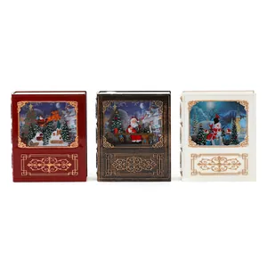 Set di tre lanterne natalizie a forma di libro con Babbo Natale e pupazzo di neve.