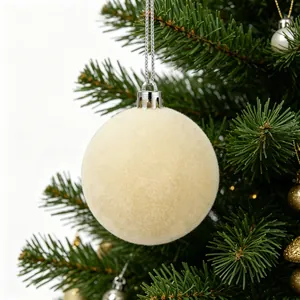 Primo piano di una pallina di Natale floccata bianco crema su un albero di pino