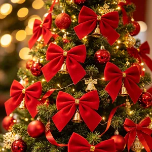 Close-up of red velvet bows with small gold bells decorating a lush Christmas tree.